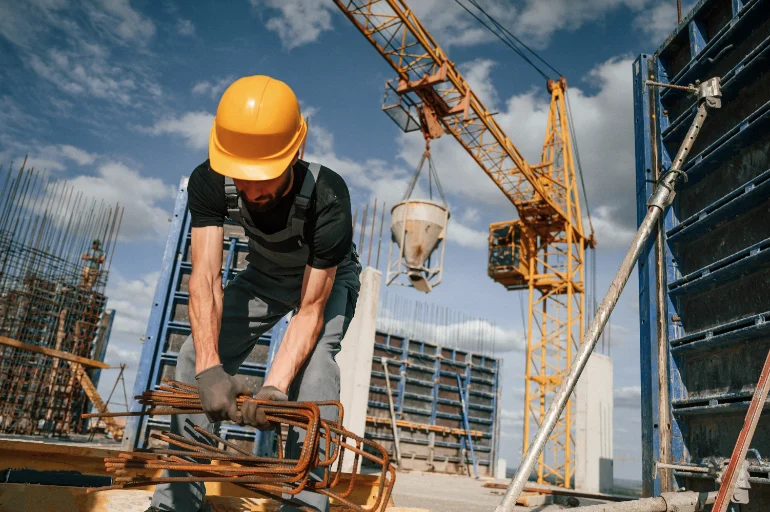 Worker handling reinforcing steel at a construction site