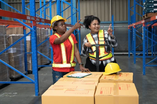 Warehouse workers moving packages with lifting equipment