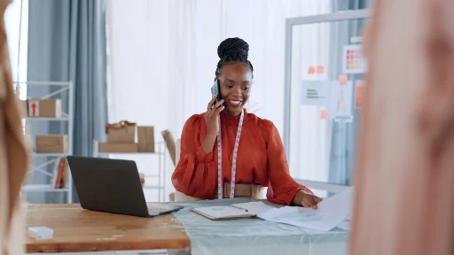 Woman reviewing design sketches while speaking on the phone